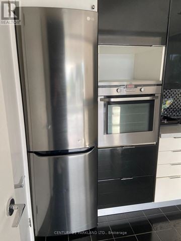 Toronto (Annex) condo for rent - A stainless steel refrigerator stands in a kitchen.