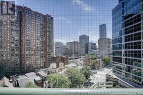 Toronto (Bay Street Corridor) condo for rent - A cityscape with buildings of various heights and a green roofed structure in the foreground.