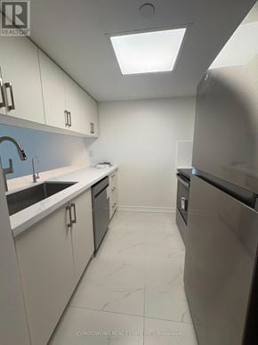 Toronto (Bay Street Corridor) condo for rent - A kitchen with white cabinets and a black fridge.