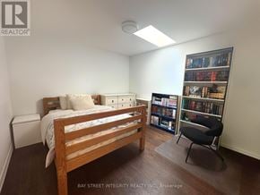 Toronto (Trinity-Bellwoods) townhouse for rent - A bedroom with a bed, chair, and bookshelf.