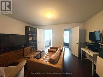 Toronto (Trinity-Bellwoods) townhouse for rent - A living room with a brown leather couch and a flat screen TV.