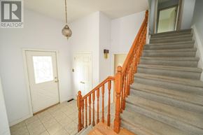 Oakville (Br Bronte) apartment for rent - A staircase with a wooden railing leads to a doorway.