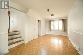 Oakville (Br Bronte) apartment for rent - A spacious room with wooden flooring and white walls.