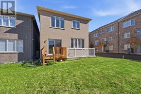Oshawa (Taunton) apartment for rent - A brown brick house with a white fence and a green lawn.