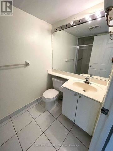 Toronto (Willowdale East) condo for rent - A white bathroom with a toilet, sink, and mirror.