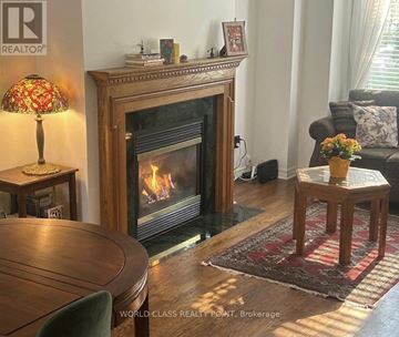 Markham (Commerce Valley) townhouse for rent - A living room with a fireplace and a lamp on a side table.