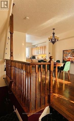 Markham (Commerce Valley) townhouse for rent - A wooden staircase leads to a dining area with chairs and a table.