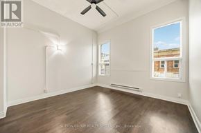 Toronto (Kensington-Chinatown) condo for rent - A room with a ceiling fan and a window showing a building outside.