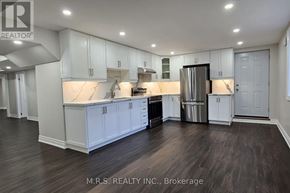 Georgina (Sutton & Jackson's Point) apartment for rent - A spacious kitchen with white cabinets and a dark floor.