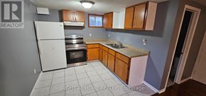 Brampton (Brampton South) apartment for rent - A kitchen with a white refrigerator, wooden cabinets, and a granite countertop.