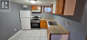 Brampton (Brampton South) apartment for rent - A kitchen with a white refrigerator, brown cabinets, and a granite countertop.