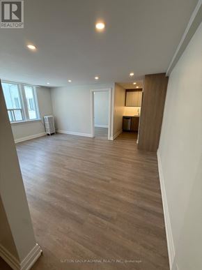 Toronto (Forest Hill South) house for rent - A spacious room with wood flooring and a small kitchenette in the corner.