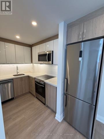 Toronto (Forest Hill South) house for rent - A modern kitchen with a stainless steel refrigerator and wooden cabinets.