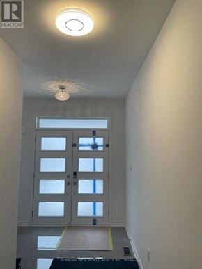 Innisfil apartment for rent - A white door with a glass panel is in the middle of a hallway.