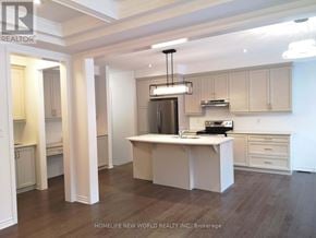 Innisfil apartment for rent - A modern kitchen with a center island and a refrigerator with a light above it.