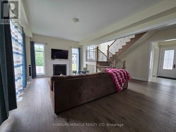 Oro-Medonte apartment for rent - A living room with a brown couch and a staircase.