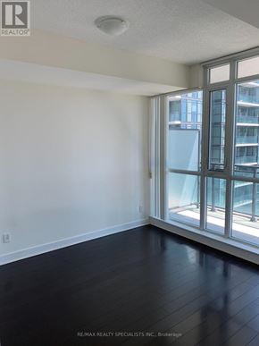 Mississauga (City Centre) condo for rent - A room with a large window and a view of a building outside.