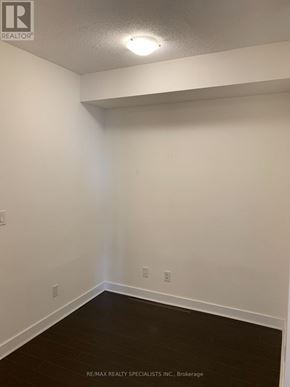 Mississauga (City Centre) condo for rent - A white room with a wooden floor and a light on the ceiling.