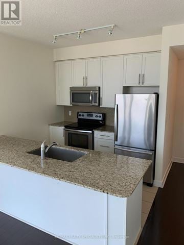 Mississauga (City Centre) condo for rent - A kitchen with a granite countertop and stainless steel appliances.