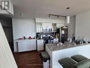 Toronto (Bay Street Corridor) condo for rent - A kitchen with a refrigerator, stove, and cabinets.