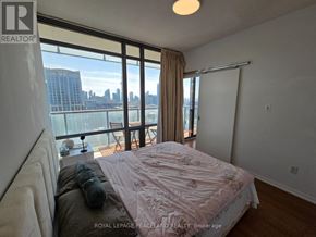Toronto (Bay Street Corridor) condo for rent - A bedroom with a large bed and a view of the city.