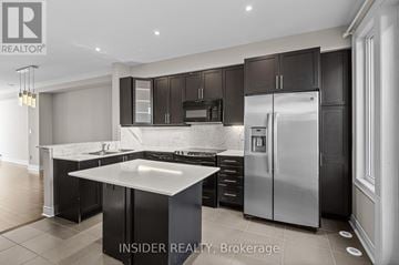 Mississauga (Applewood) townhouse for rent - A modern kitchen with dark brown cabinets and stainless steel appliances.