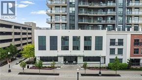 Waterloo condo for rent - A white building with a Realtor sign in front of it.