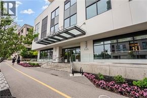 Waterloo condo for rent - A modern building with a glass facade and a flower bed in front.