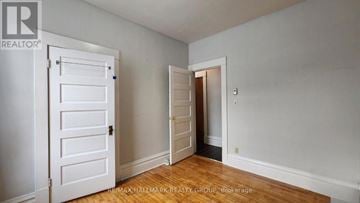 Ottawa multi-family for rent - A room with a white door and a wooden floor.