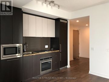 Toronto (Waterfront Communities) condo for rent - A kitchen with dark brown cabinets and stainless steel appliances.