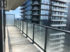 Toronto (Waterfront Communities) condo for rent - A balcony with a metal railing and a glass door leading to a building.