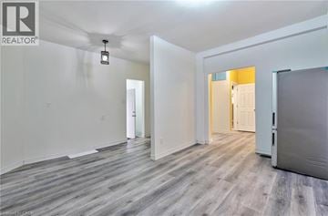 Hamilton apartment for rent - A spacious room with wood flooring and white walls.