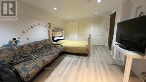 Toronto (Bayview Village) apartment for rent - A living room with a sofa, a bed, and a television.