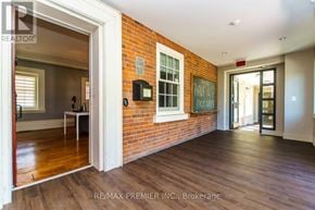 Vaughan (Kleinburg) condo for rent - A room with a brick wall and wooden floors.