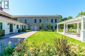 Vaughan (Kleinburg) condo for rent - A house with a white pergola and a garden in front.