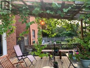 Toronto (Bayview Village) apartment for rent - A wooden deck with a chair and a table under a pergola.