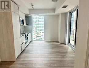 Toronto (Waterfront Communities) condo for rent - A spacious kitchen with wooden flooring and white cabinetry.