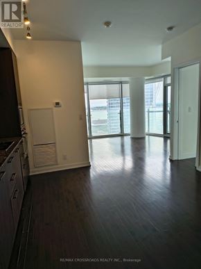 Toronto (Waterfront Communities) condo for rent - A wooden floor in a room with a white wall and a glass door.
