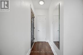Toronto (Islington-City Centre West) apartment for rent - A hallway with a mirror on the wall and a door at the end.
