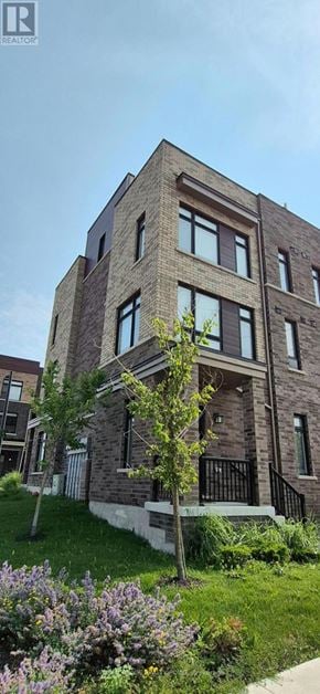 Pickering (Village East) townhouse for rent - A modern brick building with a tree in front.