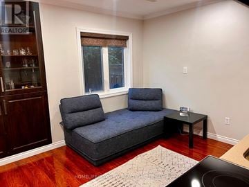 Vaughan (Patterson) apartment for rent - A living room with a grey sofa and a small table.