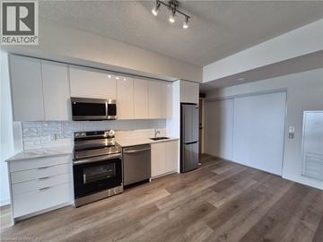 Brantford condo for rent - A modern kitchen with wooden floors and stainless steel appliances.