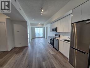 Brantford condo for rent - A kitchen with a stainless steel refrigerator, microwave, and oven.
