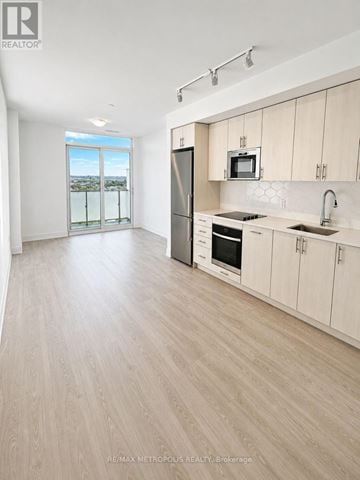 Oshawa (Windfields) condo for rent - A modern kitchen with wooden floors and white walls.