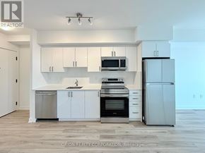 Toronto (Yorkdale-Glen Park) condo for rent - A modern kitchen with white cabinets and stainless steel appliances.