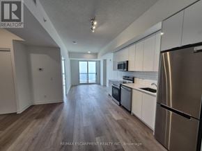 Brantford condo for rent - A kitchen with white cabinets and a stainless steel refrigerator.