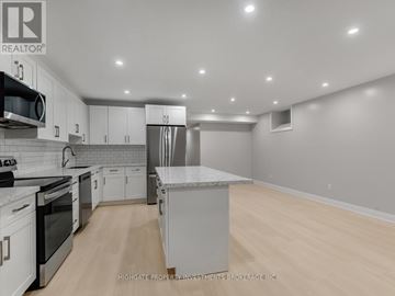 Toronto (Palmerston-Little Italy) apartment for rent - A modern kitchen with white cabinets and stainless steel appliances.