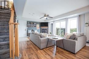Collingwood townhouse for rent - A living room with a grey couch and a ceiling fan.