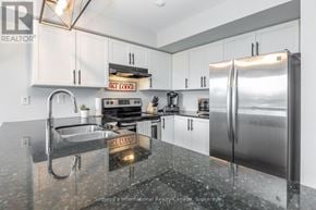 Collingwood townhouse for rent - A kitchen with a stainless steel refrigerator and a granite countertop.