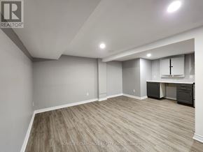 Thorold (Confederation Heights) apartment for rent - A spacious room with wood flooring and a desk area.